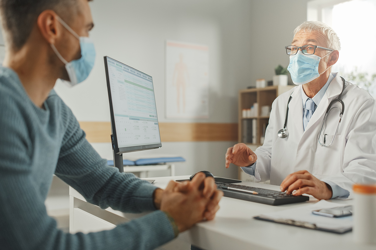 middle aged man speaking with male physician