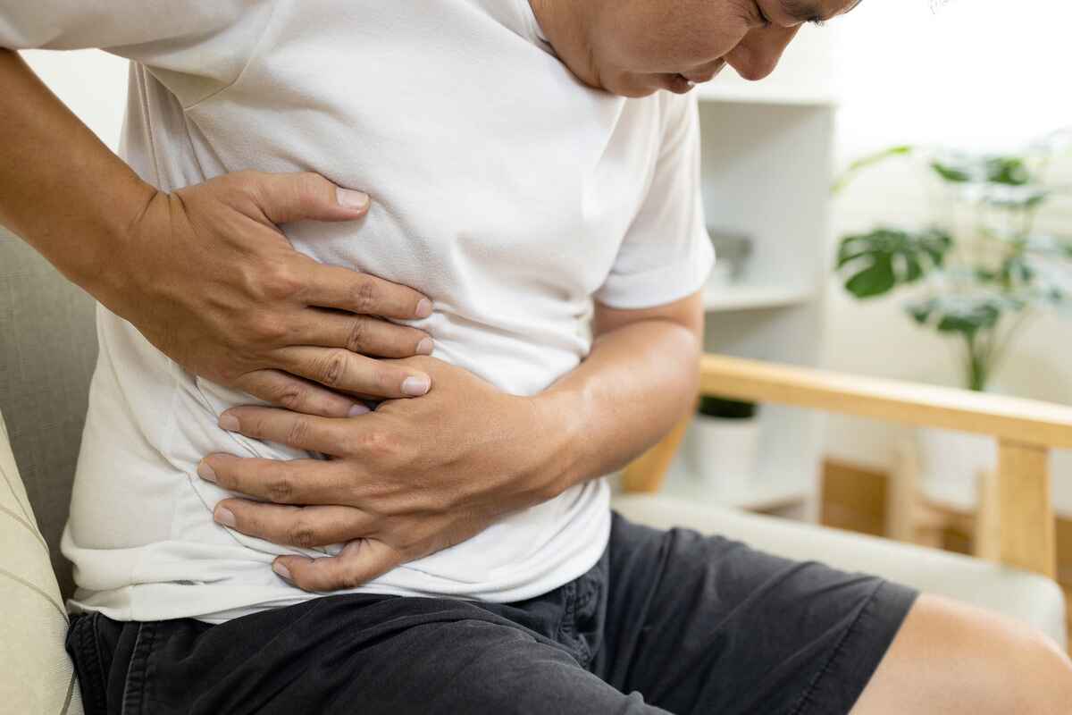 Man experiencing liver pain holds his side